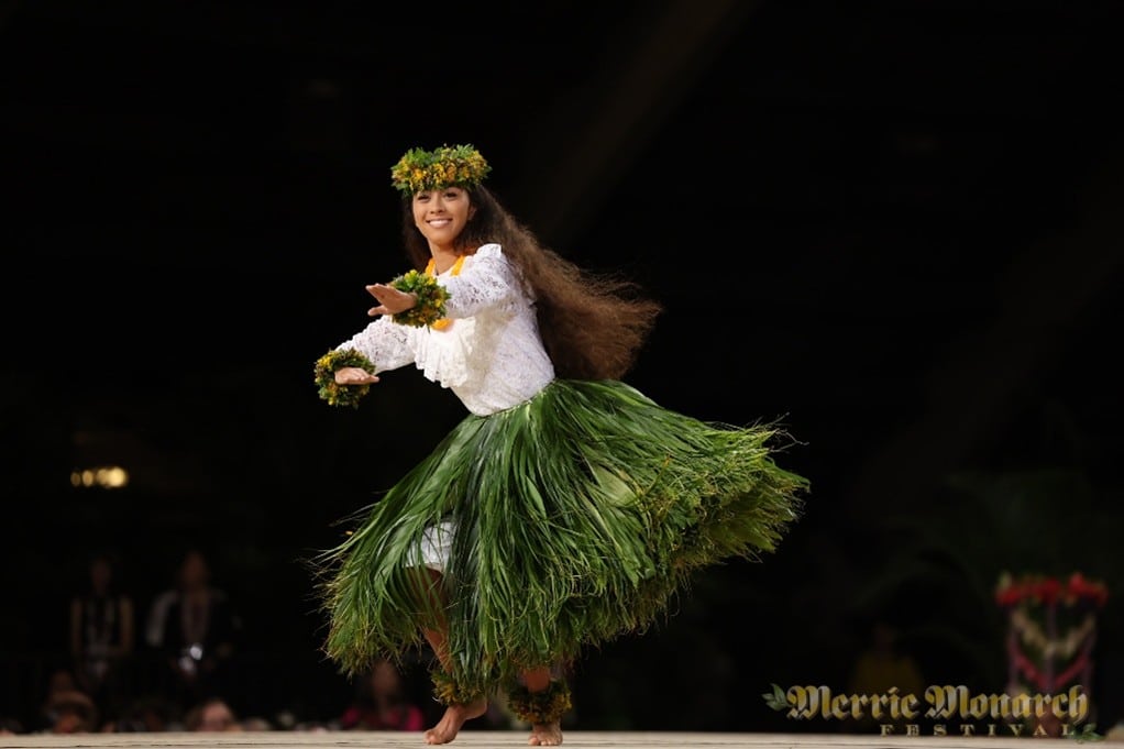 Hula dancer in white blouse and green ti leaf skirt